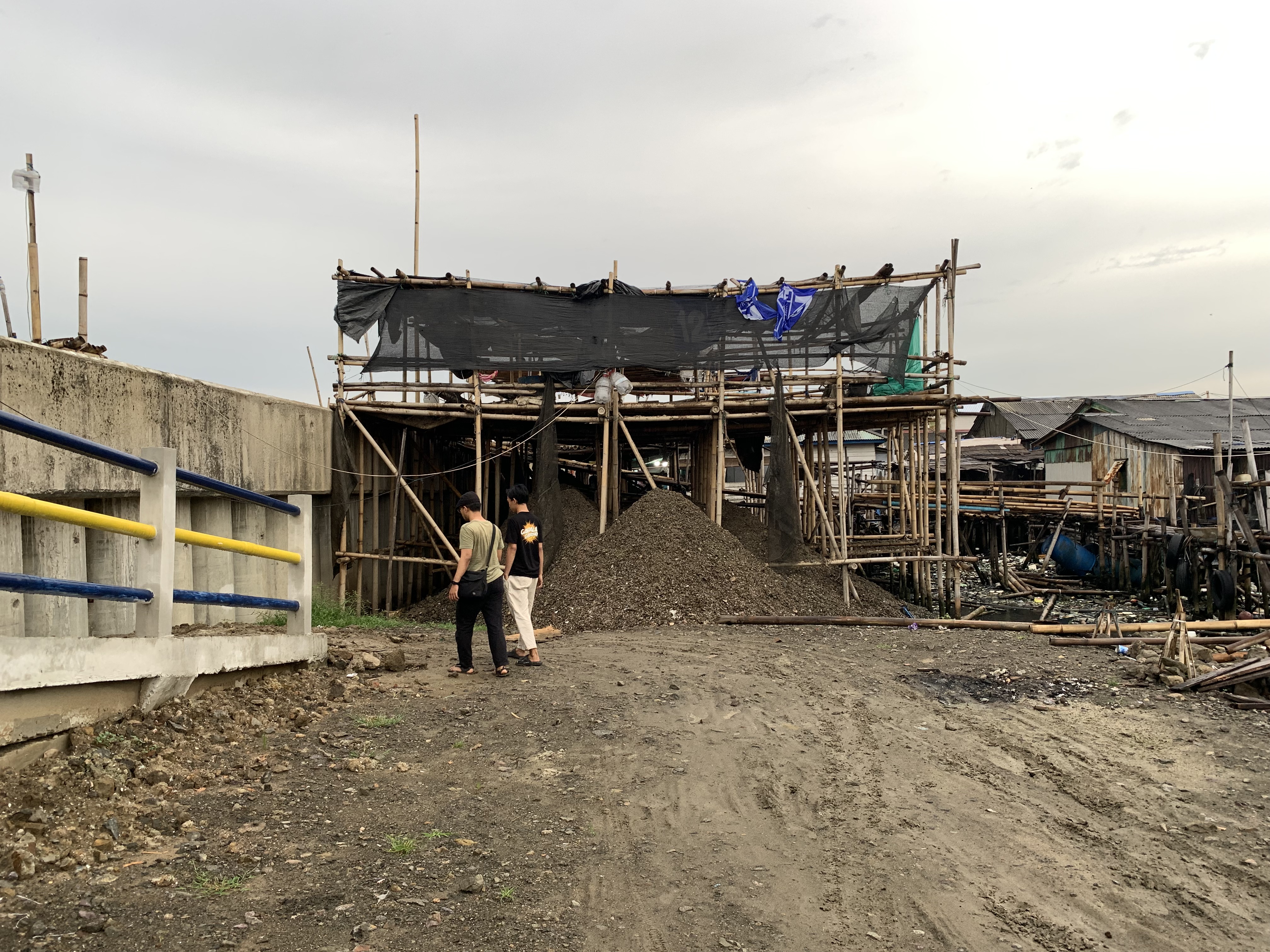 Mussel peeling site in Kamal Muara where elderly workers now face a longer, steeper walk due to seawall construction